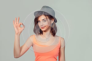 Hipster teenage girl in gray hat giving ok sign gesture