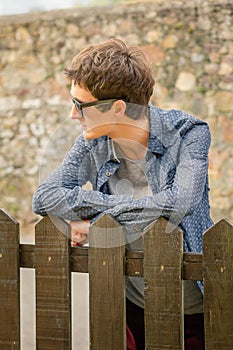 Hipster teenager with sunglasses over a fence