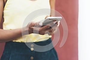 Hipster text message on smart phone or technology, mock up of blank screen. Young girl using cellphone on yellow flower background