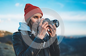 Hipster tourist girl hold in hands take photography click on modern photo camera, photographer look on camera technology, journey