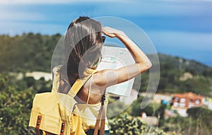 Hipster tourist hold and look map on trip, lifestyle concept adventure, traveler with backpack on background mountain and blue sea