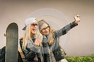 Hipster urban girlfriends taking a selfie in the city