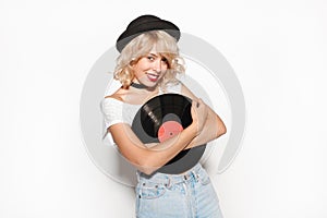 Hipster woman with blond hair holding a vinyl record