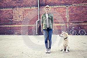 Hipster woman with dog and vintage road bike in city