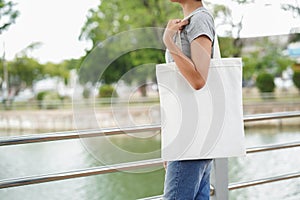 hipster woman holding white tote bag for mock up blank template