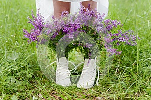 Hipster woman in the park. Creative bouquet in boots