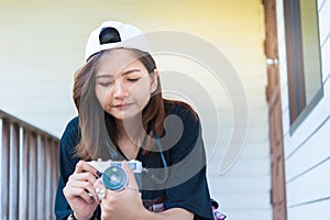 Hipster woman taking photos with retro film camera on wooden floorof city park,beautiful girl photographed in the old camera