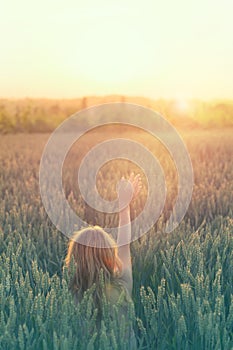 Hipster woman touches the sun with her hand in the middle of the nature photo