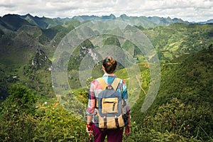 Hipster woman traveler with backpack enjoying a beautiful view o photo