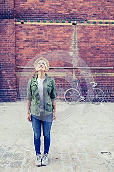 Hipster woman with vintage road bike in city