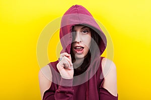 Hipster woman wearing a hood and winking to the camera