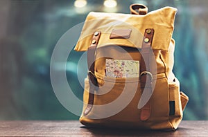 Hipster yellow backpack and map closeup. View from front tourist traveler bag on background blue sea aquarium. Person hiker visiti