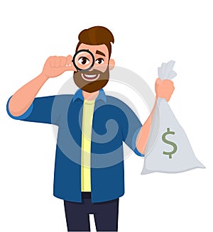 Hipster young man looking through magnifying glass or magnifier and holding cash, money bag with dollar sign. Bearded person.