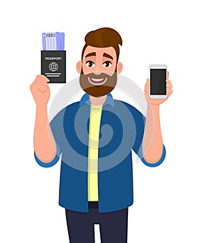 Hipster young man showing passport with tickets and blank screen phone. Trendy bearded person holding boarding pass and mobile,