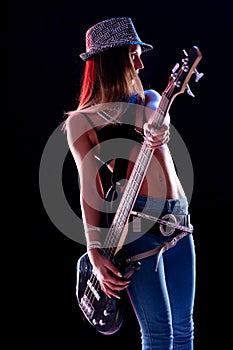 Hipster young rock star female guitarist performing on stage