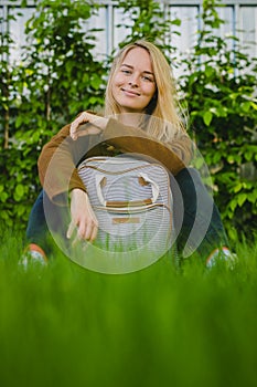 Hipster young woman in park with a backpack