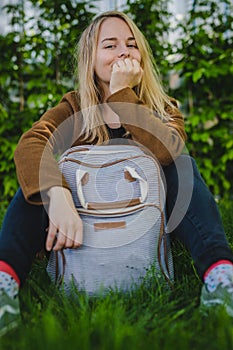 Hipster young woman in park with a backpack