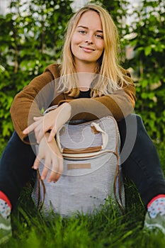 Hipster young woman in park with a backpack