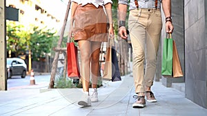 Hipsters, men and women walking on the sidewalk with shopping bags