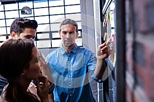 Hipsters reading a post it on a window