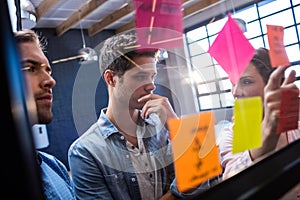 Hipsters reading a post it on a window