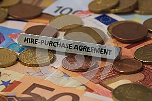 hire-purchase agreement - the word was printed on a metal bar. the metal bar was placed on several banknotes