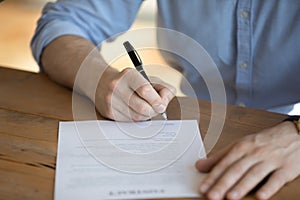 Hired employee signing employment contract, close up image