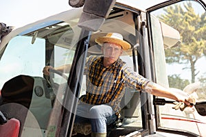 Hired worker driving farm tractor during spring works