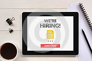 We are hiring apply now concept on tablet screen with office obj