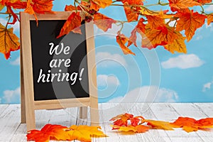 We are hiring sign with standing chalkboard with fall leaves