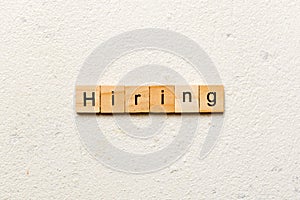 hiring word written on wood block. hiring text on table, concept