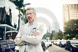 His ambition is unfaltering. Portrait of a mature businessman standing in the city.