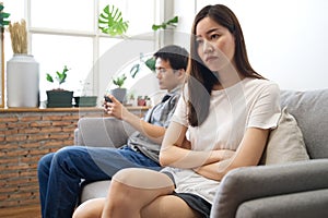 Young girl sitting on sofa is feeling angry her boyfriend.