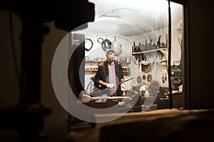 In his element. a focused young male carpenter working hard in his workshop at home during the night.