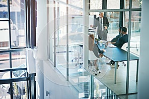 His expertise is invaluable. High angle shot of a mature businessman giving a presentation in the boardroom.