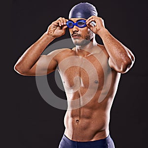 His eyes are on the prize. Studio shot of a young male swimmer.