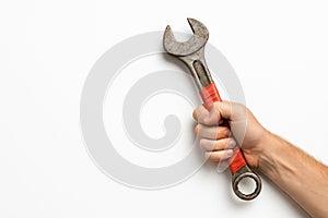 His hand holds a rusty wrench tightly. Space for text.