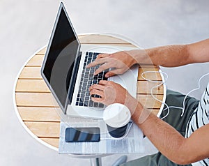 His hands are his livelihood. High angle shot of a man working on a laptop outside.