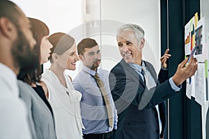 His presentation is on point. Shot of a man giving a presentation to colleagues in an office.