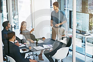 His presentations are always very informative. High angle shot of a young businessman giving a presentation in the