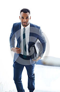 On his way to a meeting. A handsome african american businessman walking up the stairs while carrying a bag.