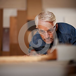 His workmanship is of the highest quality. a mature male carpenter working on a project in his workshop.