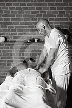 hispanic adult fit woman enjoy massage by physiotherapist in the therapeutical bed photo
