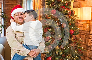 Hispanic Armed Forces Soldier Wearing Santa Hat Hugging Son