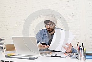 Hispanic attractive hipster businessman working at home office using mobile phone