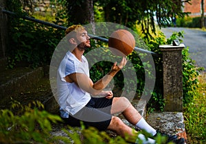 Hispanic baller posing with a basket ball spinning the ball on his finger