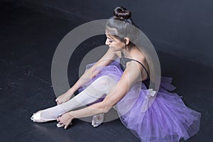 Hispanic ballerina sitting backstage photo