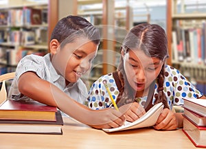 Hispanic Boy and Girl Having Fun Studying In The Library