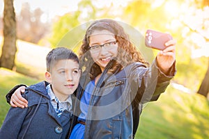 Hispanic Brother and Sister Taking Selfie with Cell Phone