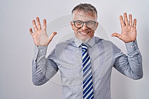 Hispanic business man with grey hair wearing glasses showing and pointing up with fingers number ten while smiling confident and